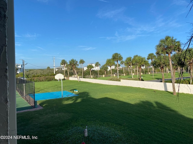 exterior space featuring basketball court and a lawn