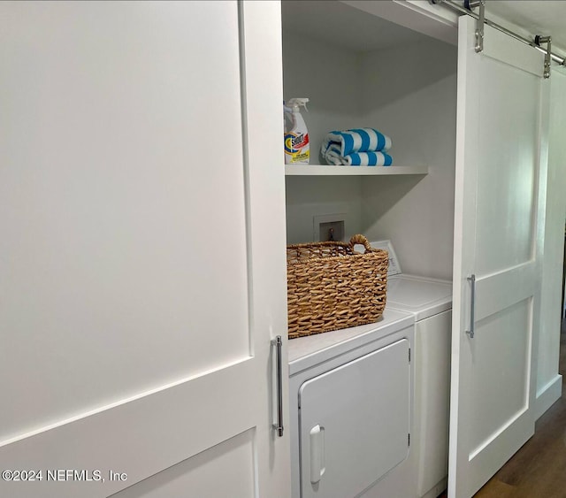 laundry area with independent washer and dryer and dark wood-type flooring