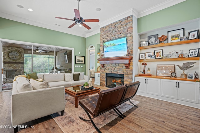 living room featuring ceiling fan, hardwood / wood-style flooring, a fireplace, and crown molding