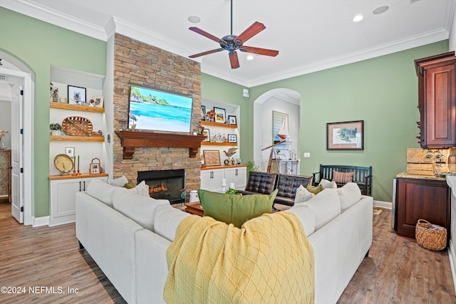 living room with ornamental molding, a fireplace, and hardwood / wood-style floors