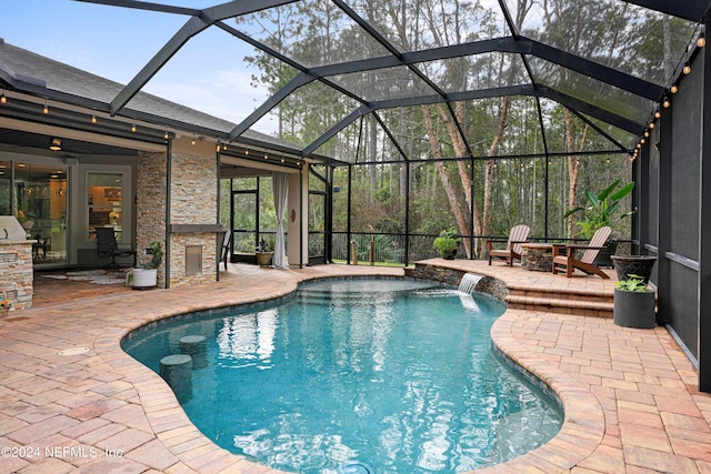 view of pool featuring glass enclosure, a patio, and pool water feature