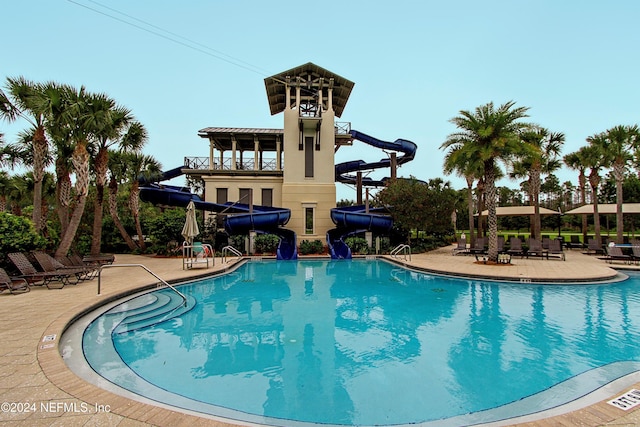 view of pool featuring a water slide and a patio