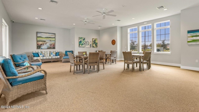 carpeted dining space with ceiling fan