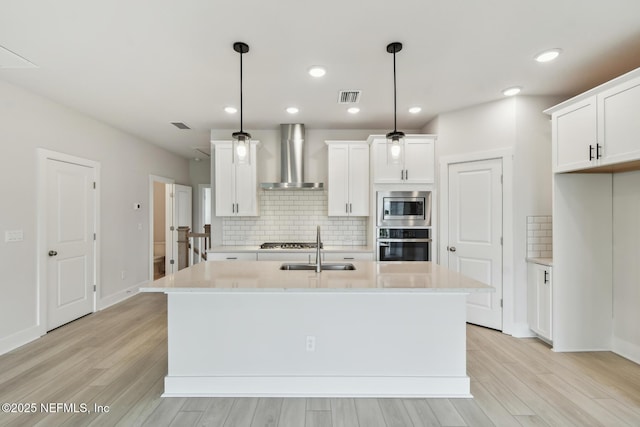 10266 Element Rd, Jacksonville, FL 32256 - kitchen with wall chimney range hood, stainless steel appliances, a sink, backsplash, and light wood finished floors