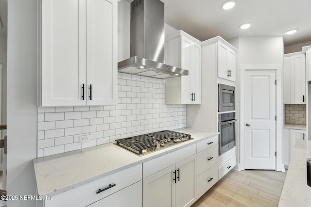 10266 Element Rd, Jacksonville, FL 32256 - kitchen with wall chimney exhaust hood, appliances with stainless steel finishes, white cabinetry, and recessed lighting