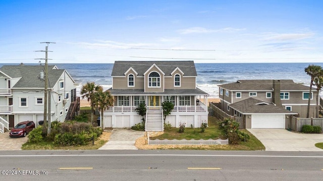 view of front facade featuring covered porch, a water view, and a garage