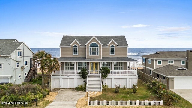 view of front of property featuring a porch, a water view, and a garage