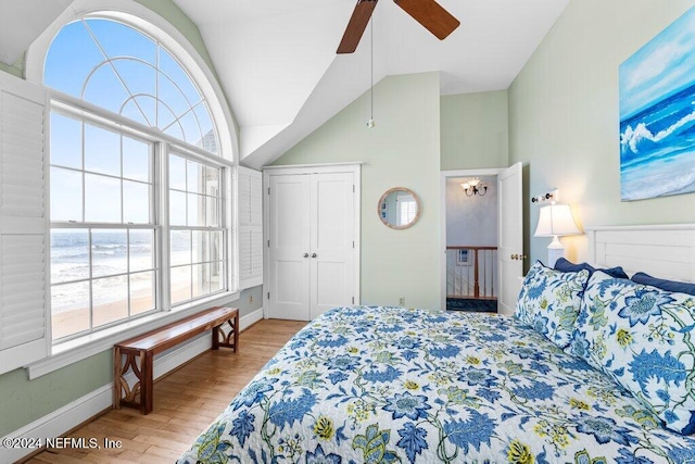 bedroom featuring multiple windows, light hardwood / wood-style floors, vaulted ceiling, and ceiling fan