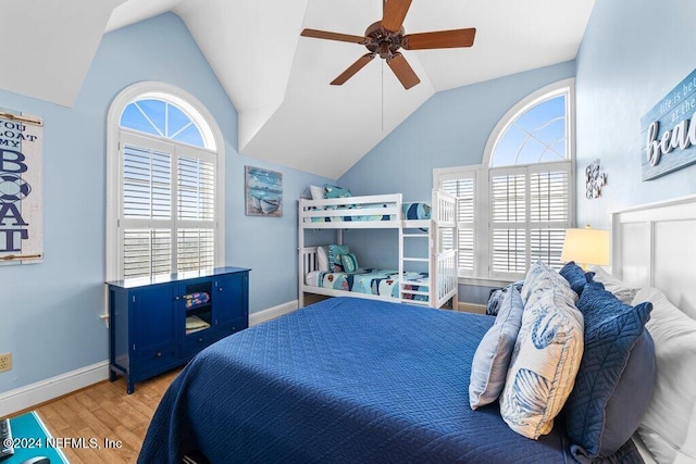 bedroom featuring ceiling fan, light hardwood / wood-style flooring, and lofted ceiling