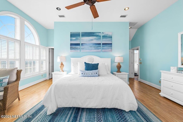 bedroom featuring ceiling fan, light wood-type flooring, and lofted ceiling