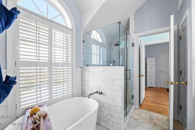 bathroom with hardwood / wood-style floors, plus walk in shower, and vaulted ceiling