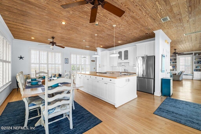 kitchen with stainless steel fridge, light hardwood / wood-style floors, white cabinetry, and wooden ceiling