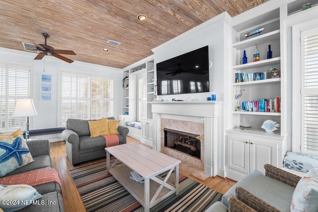 living room featuring wooden ceiling, ceiling fan, built in features, light wood-type flooring, and a fireplace