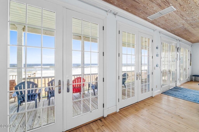 entryway featuring french doors, a water view, crown molding, light hardwood / wood-style floors, and wood ceiling