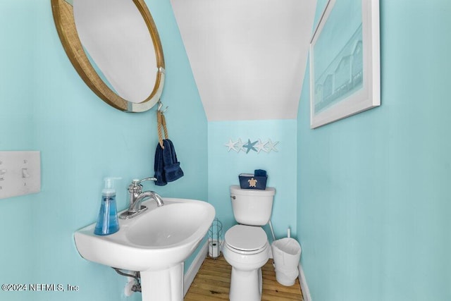 bathroom featuring lofted ceiling, toilet, wood-type flooring, and sink