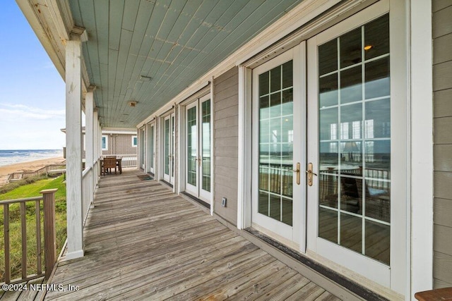 wooden terrace featuring covered porch and french doors