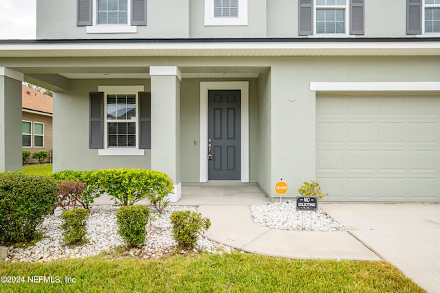 entrance to property featuring a garage and a porch