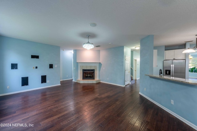 unfurnished living room featuring a fireplace and dark hardwood / wood-style floors