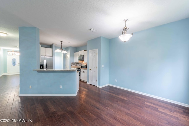 kitchen featuring dark wood-type flooring, decorative light fixtures, light stone counters, stainless steel appliances, and white cabinetry