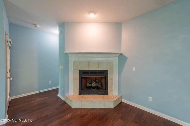 unfurnished living room with a textured ceiling, a fireplace, dark hardwood / wood-style floors, and lofted ceiling