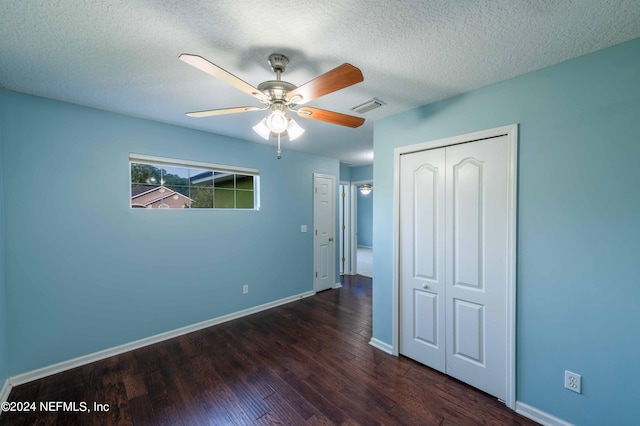 unfurnished bedroom featuring a textured ceiling, ceiling fan, a closet, and dark hardwood / wood-style flooring