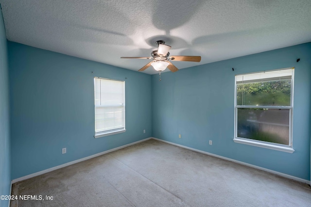 carpeted empty room with ceiling fan and a textured ceiling