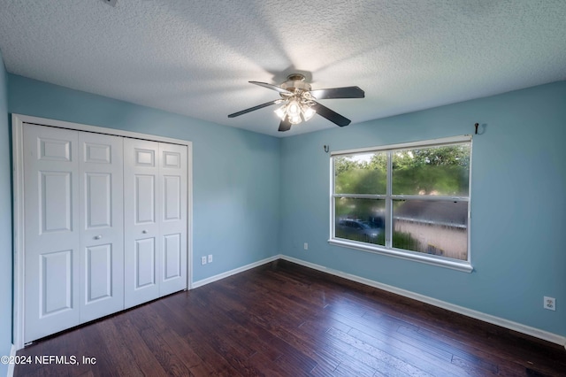 unfurnished bedroom with dark hardwood / wood-style floors, a textured ceiling, and ceiling fan