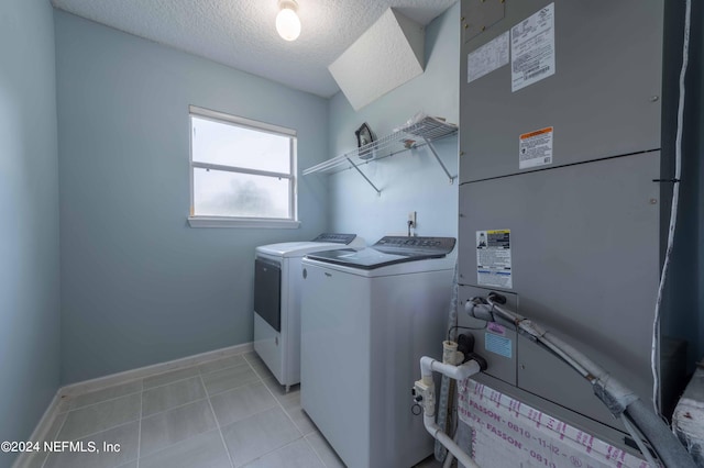 washroom with independent washer and dryer, heating unit, and a textured ceiling