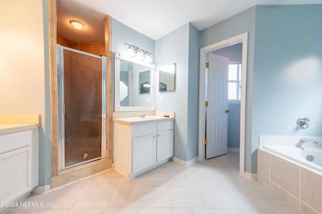 bathroom with tile patterned flooring, shower with separate bathtub, vanity, and a textured ceiling