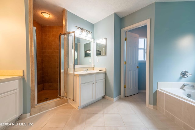 bathroom featuring a textured ceiling, vanity, and shower with separate bathtub