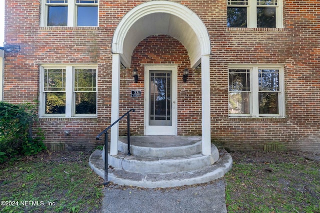 view of exterior entry featuring brick siding