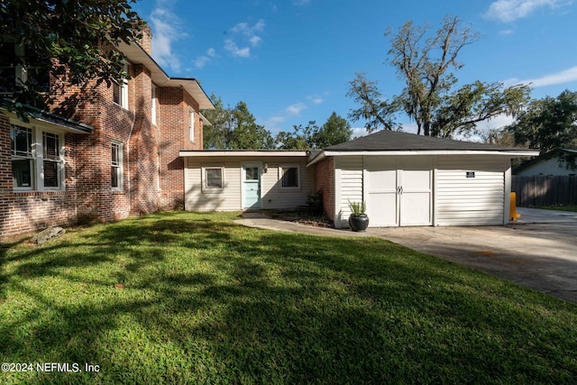 view of front of house featuring brick siding, an outdoor structure, fence, driveway, and a front lawn