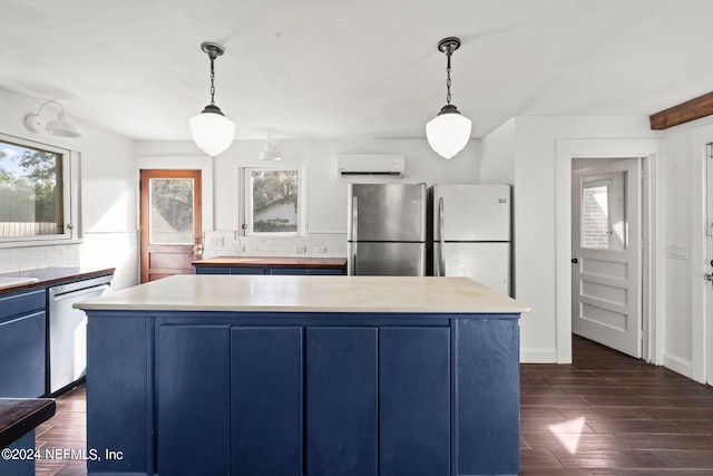 kitchen with stainless steel appliances, decorative backsplash, blue cabinetry, and dark wood-style floors