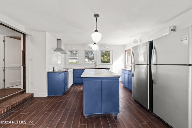 kitchen featuring white electric stove, wall chimney exhaust hood, freestanding refrigerator, and blue cabinets