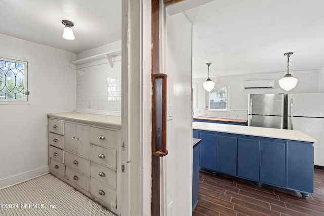 spacious closet with a wall mounted air conditioner and dark wood finished floors