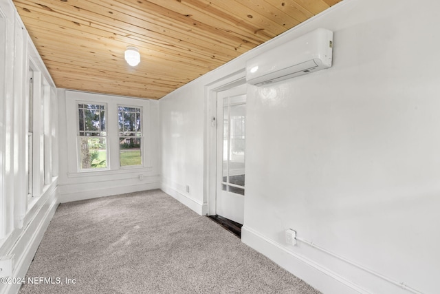 spare room featuring an AC wall unit, carpet, wood ceiling, and baseboards