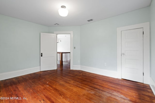 empty room with visible vents, baseboards, and wood finished floors