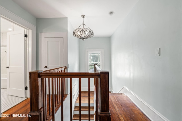 staircase featuring wood finished floors and baseboards