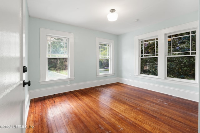 empty room with baseboards and hardwood / wood-style floors