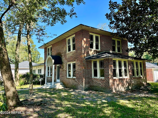 view of front of house with a front lawn and brick siding