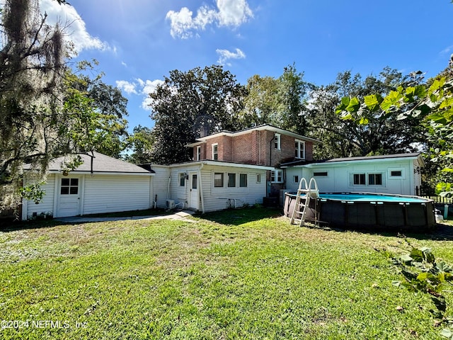 rear view of property with a lawn and an outdoor pool