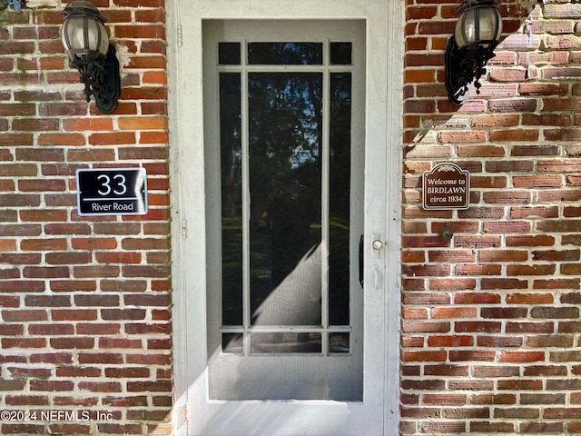 view of exterior entry with brick siding