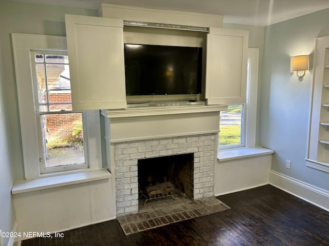 details featuring a brick fireplace, wood finished floors, and baseboards