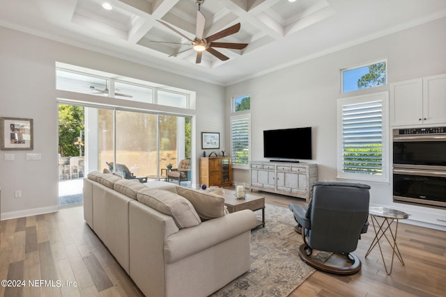 living room featuring coffered ceiling, a towering ceiling, light hardwood / wood-style floors, and crown molding