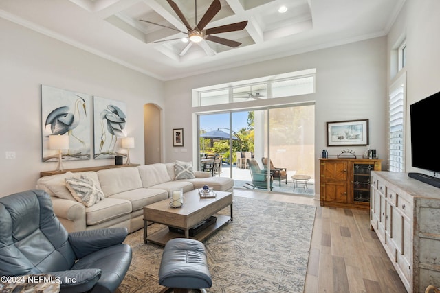 living room featuring coffered ceiling, beamed ceiling, light wood-type flooring, crown molding, and ceiling fan