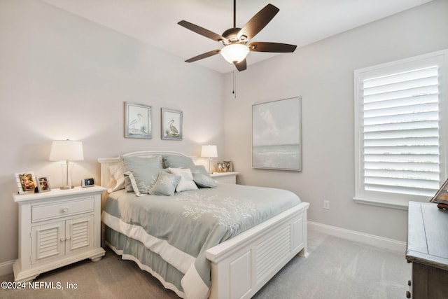 bedroom featuring multiple windows, ceiling fan, and light colored carpet