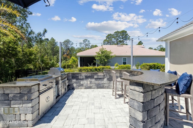 view of patio / terrace with exterior kitchen, exterior bar, and a grill