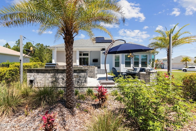 back of house featuring exterior bar and a patio area