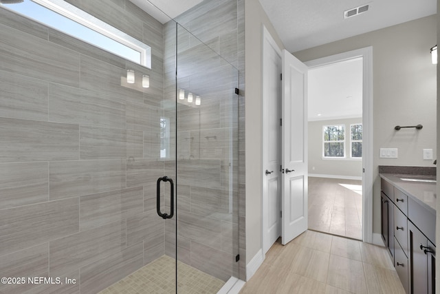 bathroom featuring tile patterned flooring, vanity, and a shower with door