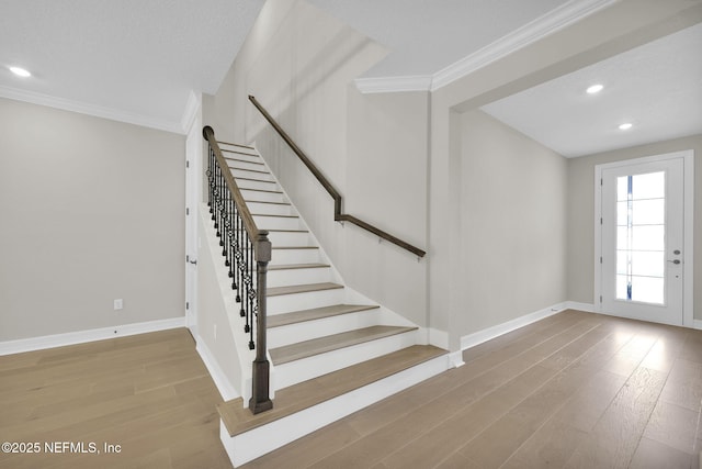 staircase featuring hardwood / wood-style flooring and ornamental molding